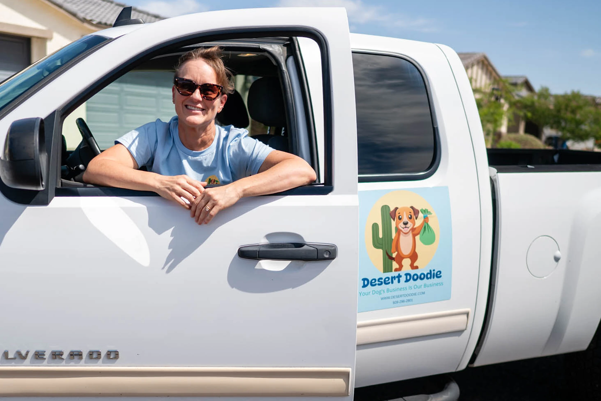 image 5 A woman smiling and leaning out of a white truck window.